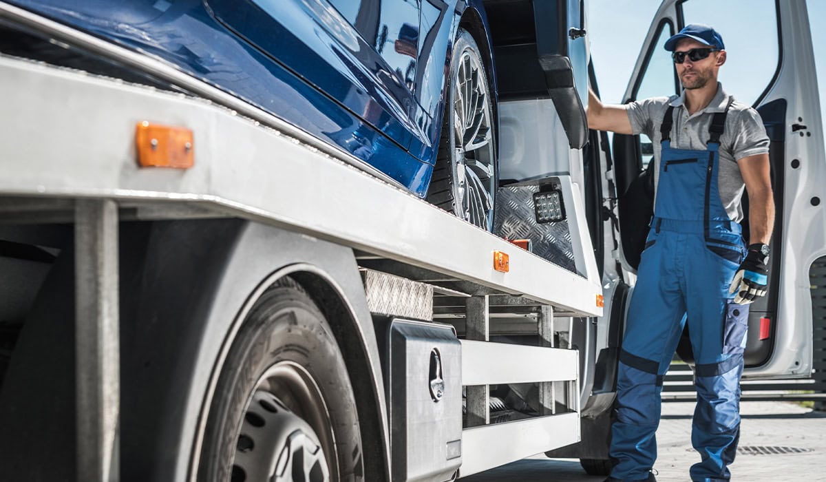 a man in a blue uniform loading a car